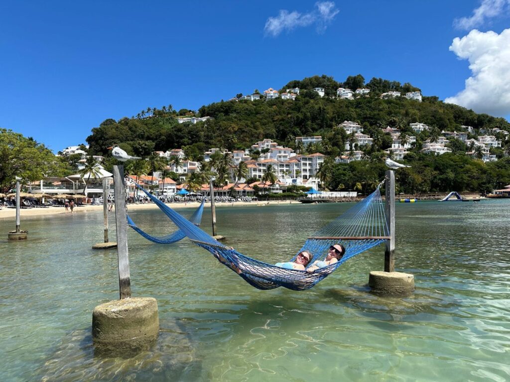 hammock over the bay People laying in a hammock suspended over the water.