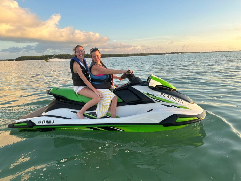 Jet Ski Two women on a jet ski on clear green water.